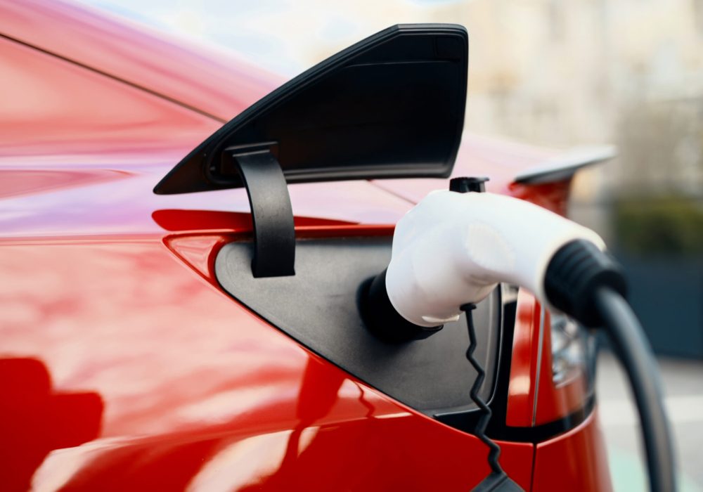 Close view of charging electric red car